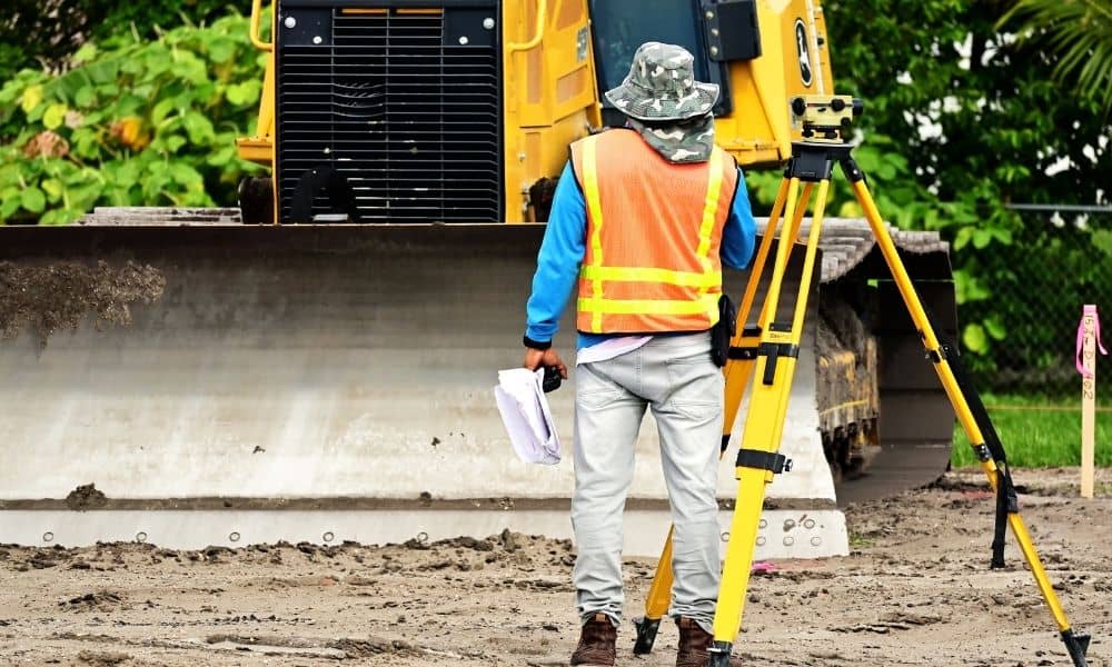 Professional surveyor using a total station, illustrating why finding property lines requires accurate field measurements